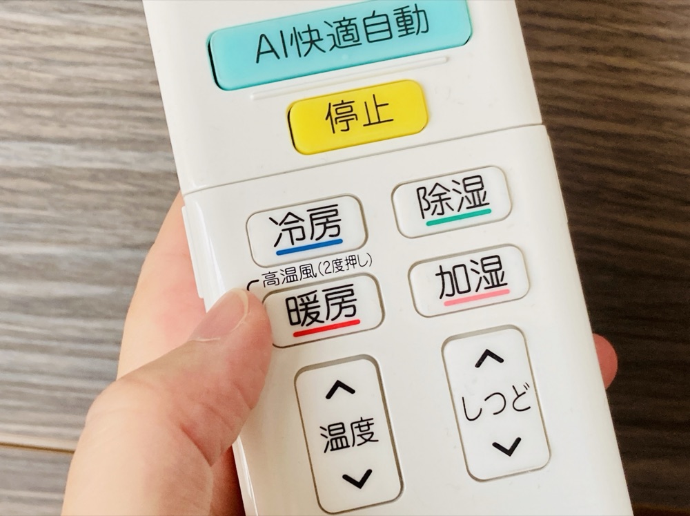 エアコンのリモコンで操作する様子