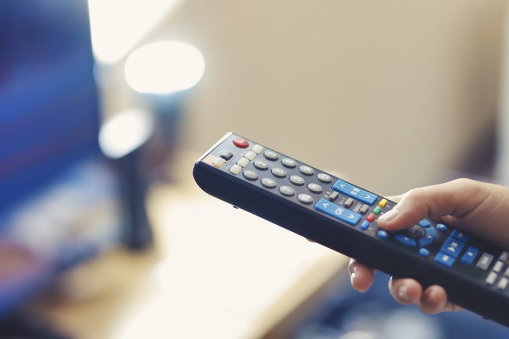 リモコンをテレビに向けて操作している様子